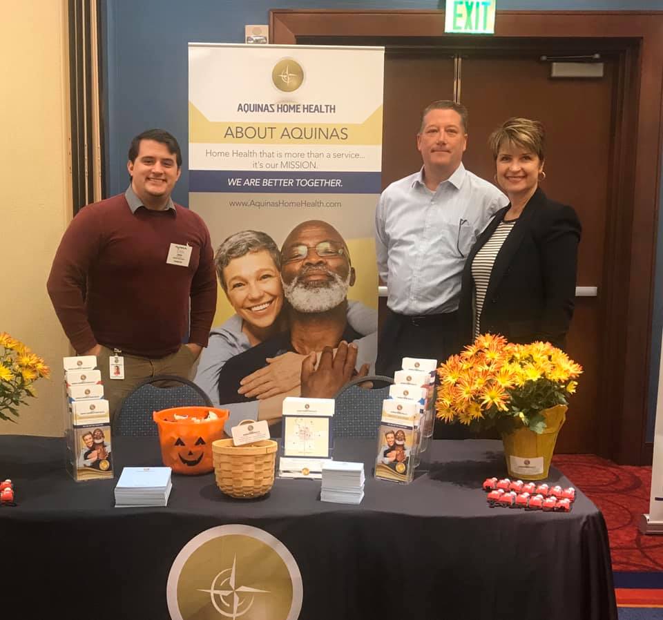 Aquinas employees at their trade show booth.