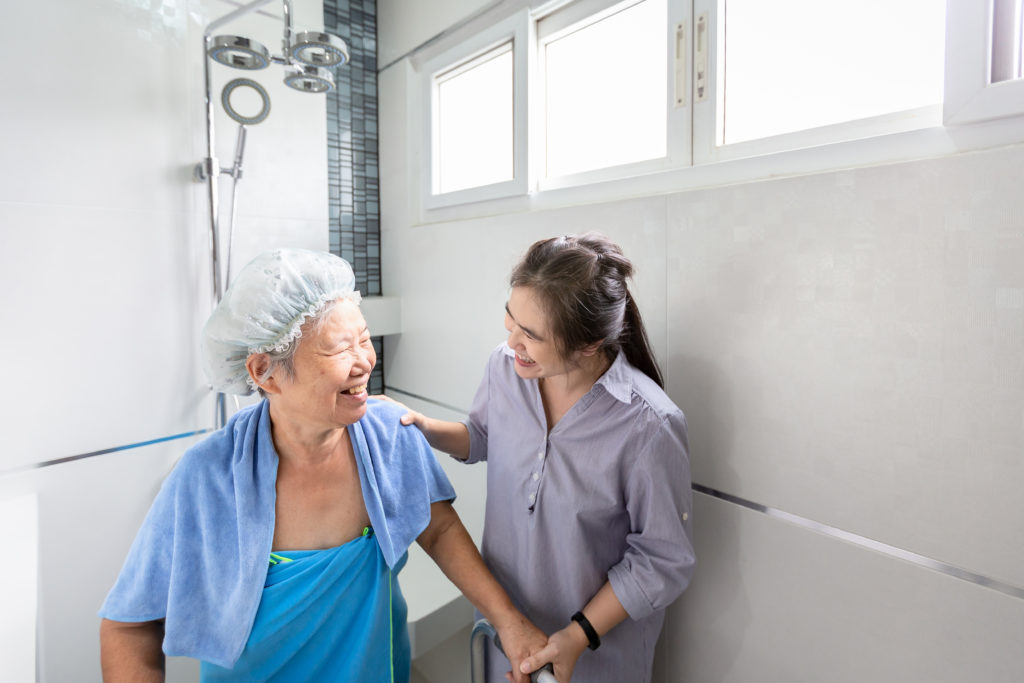 In-home nurse helping an elderly woman out of the shower.